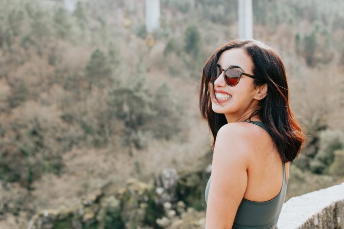 woman-in-round-sunglasses-smiles-wide
